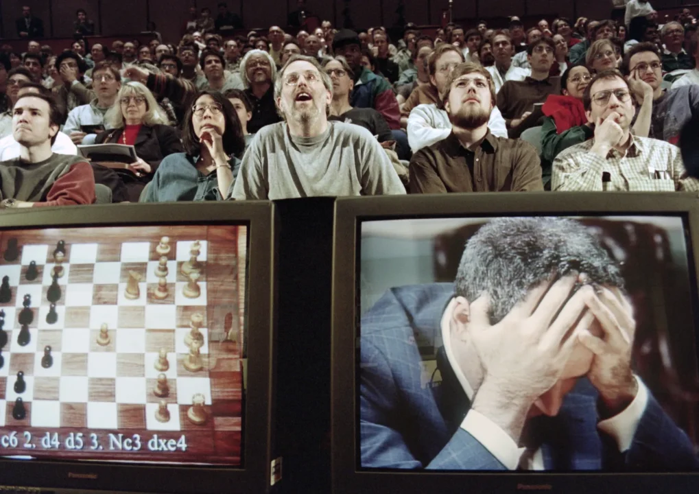 Foto che mostra Kasparov demoralizzato e il pubblico che guarda ammirato